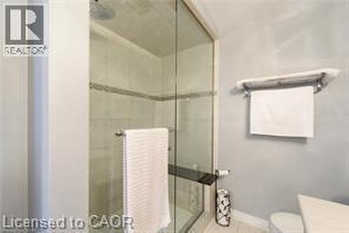 Glass-enclosed shower with tile surround and integrated shelving - 28 Madonna Drive, Hamilton, ON 