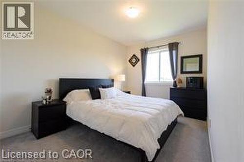 Wall-to-wall carpeting with light-toned walls and a window with dark drapery - 28 Madonna Drive, Hamilton, ON 