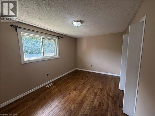 Wood-finish flooring, neutral wall paint, and white trim throughout - 37 Elora Drive, Hamilton, ON 