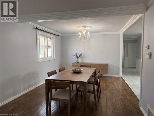 Wood-finish flooring, crown molding, chandelier with ceiling medallion, double-hung window, and wood-toned built-in cabinetry - 37 Elora Drive, Hamilton, ON 