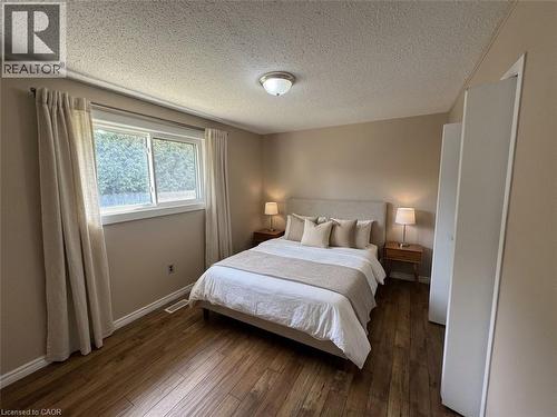 Wood-finish flooring, neutral wall tones, and a window with white trim - 37 Elora Drive, Hamilton, ON 