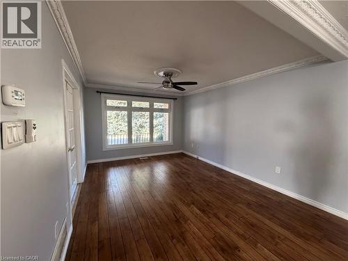 Hardwood flooring, decorative crown molding, large multi-pane window, ceiling fan with light fixture, and French-style interior door - 37 Elora Drive, Hamilton, ON 