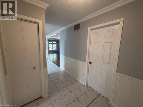 Hallway with tiled flooring, wainscoting, and crown molding - 37 Elora Drive, Hamilton, ON 