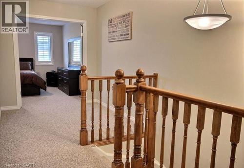 Wood-finish staircase railing and balusters with a carpeted landing - 507 Beaumont Crescent, Kitchener, ON 