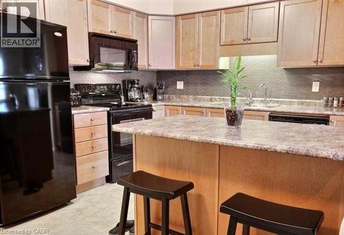 Kitchen featuring wood-finish cabinetry, black appliances, a stone-finish countertop, and a tiled backsplash - 507 Beaumont Crescent, Kitchener, ON 