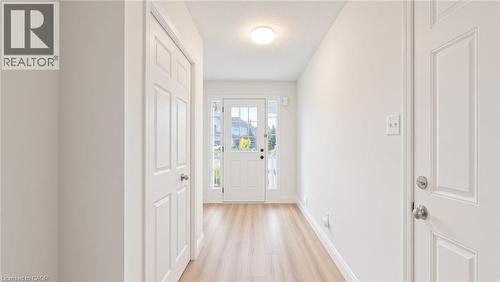 Entryway with light wood-finish flooring, white paneled doors, and a ceiling-mounted light fixture - 250 Parkvale Drive, Kitchener, ON 