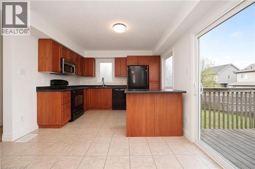 Kitchen featuring wood-finish cabinetry, dark countertops, and stainless steel and black appliances - 250 Parkvale Drive, Kitchener, ON 
