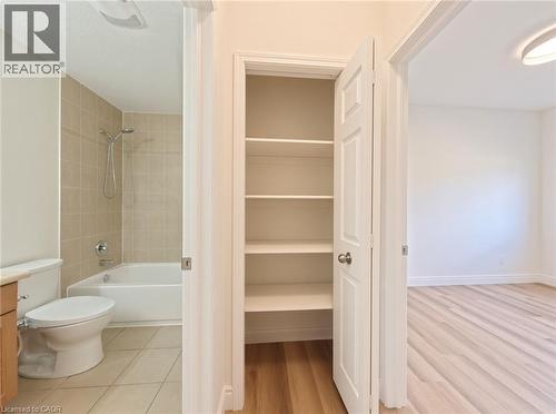 Bathroom featuring a white bathtub, ceramic wall tiling, and a toilet - 250 Parkvale Drive, Kitchener, ON 
