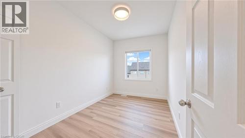 Bright room featuring light wood-finish flooring, white trim, and a window with a white frame - 250 Parkvale Drive, Kitchener, ON 