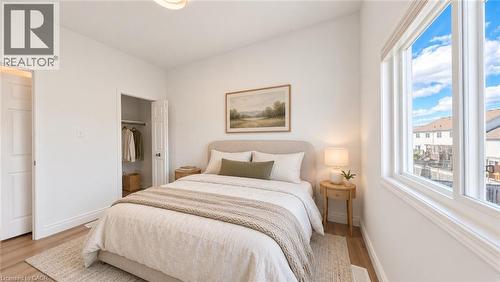 Wood-finish flooring, white walls, built-in closet, large window, and overhead lighting - 250 Parkvale Drive, Kitchener, ON 