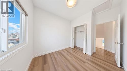 Light wood-finish flooring, white walls, and a large window providing natural illumination - 250 Parkvale Drive, Kitchener, ON 