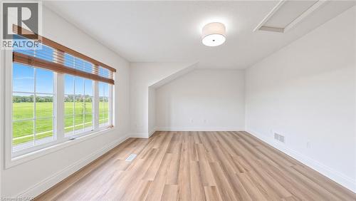 White walls, wood-finish flooring, white trim, track lighting, and a window with horizontal blinds - 250 Parkvale Drive, Kitchener, ON 