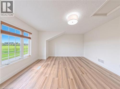 Wood-finish flooring, white walls, and a large window with wood blinds - 250 Parkvale Drive, Kitchener, ON 