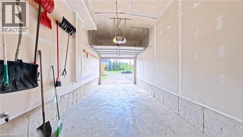 Attached garage with a concrete floor, automatic garage door opener, and unfinished drywall walls - 250 Parkvale Drive, Kitchener, ON 