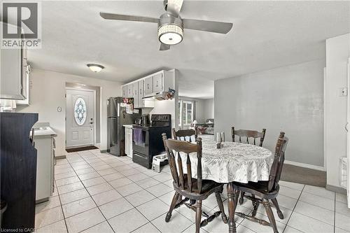 Kitchen with white tile flooring, white cabinetry, dark appliances, and a ceiling fan with integrated lighting - 135 Cedarhill Crescent, Kitchener, ON 