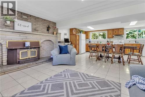 Stone-surround fireplace with hearth, built-in wood stove, and a stone accent wall - 2344 Brinell Avenue, Burlington, ON 