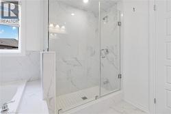 Full bath with marble look tile flooring, a marble finish shower, and a garden tub - 