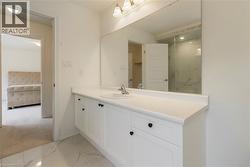 Ensuite bathroom with vanity, a marble finish shower, and marble finish floors - 