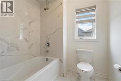 Full bathroom featuring marble finish flooring and  shower combination - 