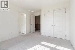 Unfurnished bedroom with light carpet and a closet - 