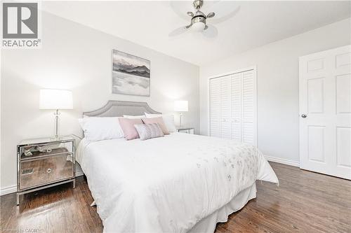 Hardwood-finish flooring, a ceiling fan with integrated lighting, a panel door, and louvered bifold closet doors - 388 Appleby Line, Burlington, ON 