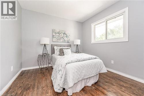 Wood-finish flooring with white trim, light gray painted walls, and a white framed window - 388 Appleby Line, Burlington, ON 