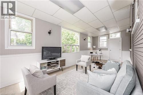 Recessed panel ceiling, wood-finish flooring, multiple windows, decorative wall sconces, and beadboard wainscoting - 388 Appleby Line, Burlington, ON 