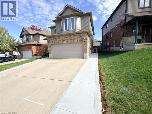 Brick and siding exterior with an attached garage, featuring a concrete driveway and an adjacent walkway - 304 Westpark Crescent, Waterloo, ON 