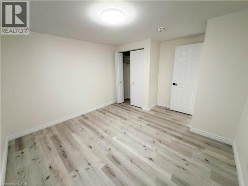 Light-toned wood-finish flooring, white walls, and a built-in closet with bi-fold doors - 304 Westpark Crescent, Waterloo, ON 