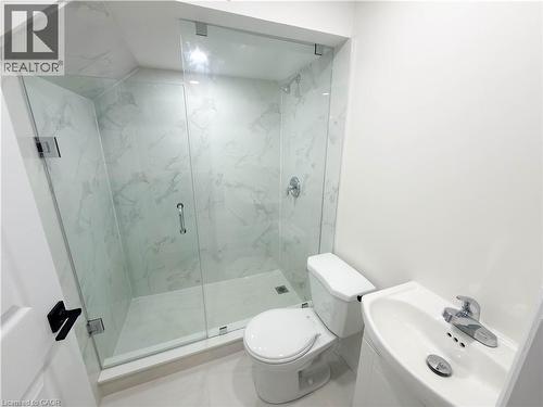 Glass-enclosed shower with white marble-finish tile, chrome fixtures, and a white toilet - 304 Westpark Crescent, Waterloo, ON 