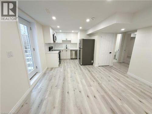 Modern kitchen featuring white cabinetry, stainless steel appliances, and a light-toned wood-finish flooring - 304 Westpark Crescent, Waterloo, ON 