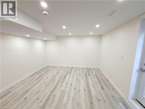 Recessed lighting illuminates the spacious room featuring light wood-finish flooring and white walls - 304 Westpark Crescent, Waterloo, ON 