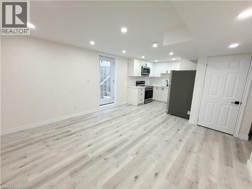 Recessed lighting, wood-finish flooring, white cabinetry, stainless steel appliances, and a glass-paneled exterior door - 304 Westpark Crescent, Waterloo, ON 