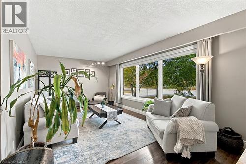 Hardwood-finish flooring, large picture window, recessed lighting, and light neutral wall color - 617 Scenic Drive, Hamilton, ON 