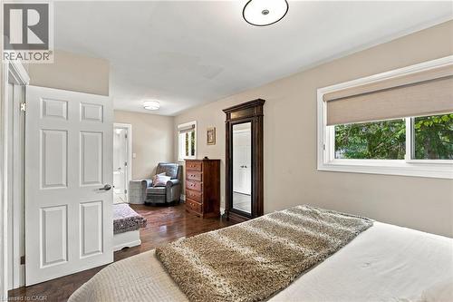 Hardwood flooring throughout, neutral wall tones, six-panel interior door, and window with roller shade - 617 Scenic Drive, Hamilton, ON 