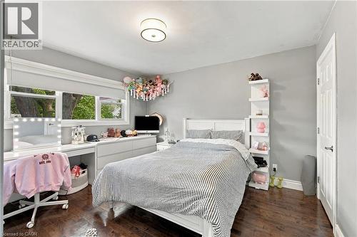 Hardwood-finish flooring, built-in shelving, and a panel door with dark hardware - 617 Scenic Drive, Hamilton, ON 