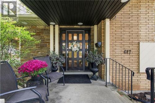 Two-tone exterior with stone and brick cladding, black entry door with transom windows, and an overhead soffit with recessed lighting - 617 Scenic Drive, Hamilton, ON 