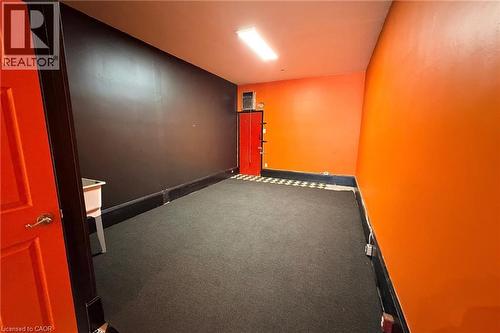 Black carpeting with a checkerboard floor accent - 319 King Street E, Hamilton, ON 