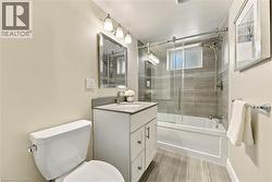 Modern bathroom featuring a sleek vanity with white cabinetry and rectangular sink, quartz countertop, and chrome fixtures - 