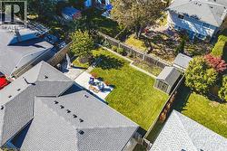 Expansive backyard oasis featuring a meticulously manicured lawn, mature shade trees, and composite deck with integrated seating - 