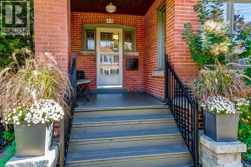 Brick exterior with wood-finish steps and porch flooring - 43 Rosslyn Avenue S, Hamilton, ON 