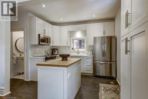 Kitchen featuring recessed lighting, white cabinetry, a wood-finish island countertop, stainless steel appliances, and tile flooring - 43 Rosslyn Avenue S, Hamilton, ON 