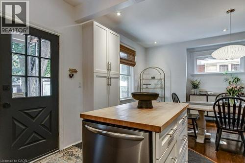 Kitchen featuring a butcher block island, stainless steel appliance, white cabinetry, dark wood-finish flooring, and recessed lighting - 43 Rosslyn Avenue S, Hamilton, ON 