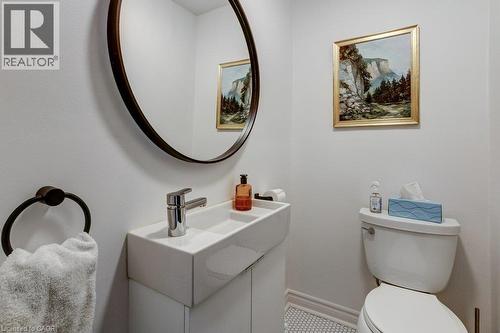White ceramic toilet and wall-mounted sink with chrome faucet - 43 Rosslyn Avenue S, Hamilton, ON 