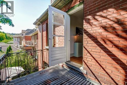 Brick exterior with decorative iron railing and outdoor balcony access - 43 Rosslyn Avenue S, Hamilton, ON 