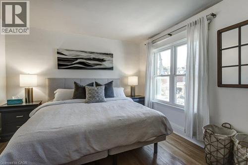 Hardwood flooring, light-toned walls, and a large window with white trim - 43 Rosslyn Avenue S, Hamilton, ON 
