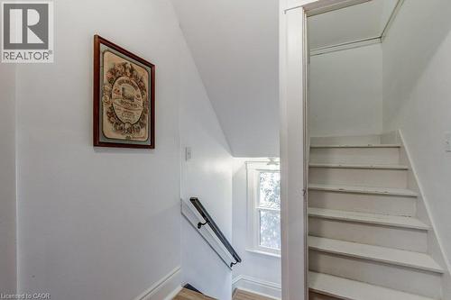 White painted staircase with a black metal handrail - 43 Rosslyn Avenue S, Hamilton, ON 
