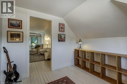 Attic space with painted wood-finish flooring, a shelving unit, and a doorway opening to an additional room - 43 Rosslyn Avenue S, Hamilton, ON 
