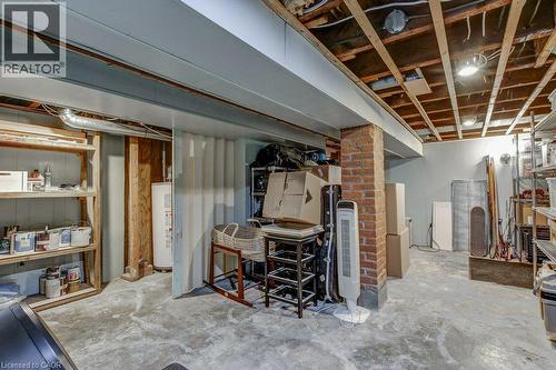 Exposed ceiling joists with visible electrical conduits, brick pillar, painted structural beams, and concrete flooring - 43 Rosslyn Avenue S, Hamilton, ON 