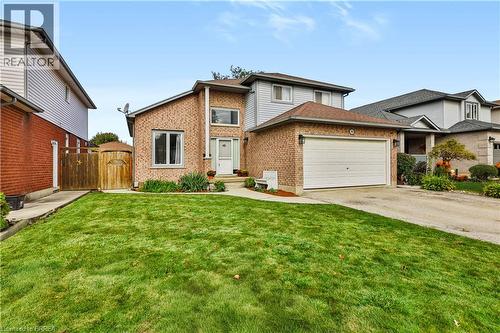 Brick and siding exterior with an attached garage, paved driveway, and established front landscaping - 19 Hyslop Drive, Caledonia, ON 
